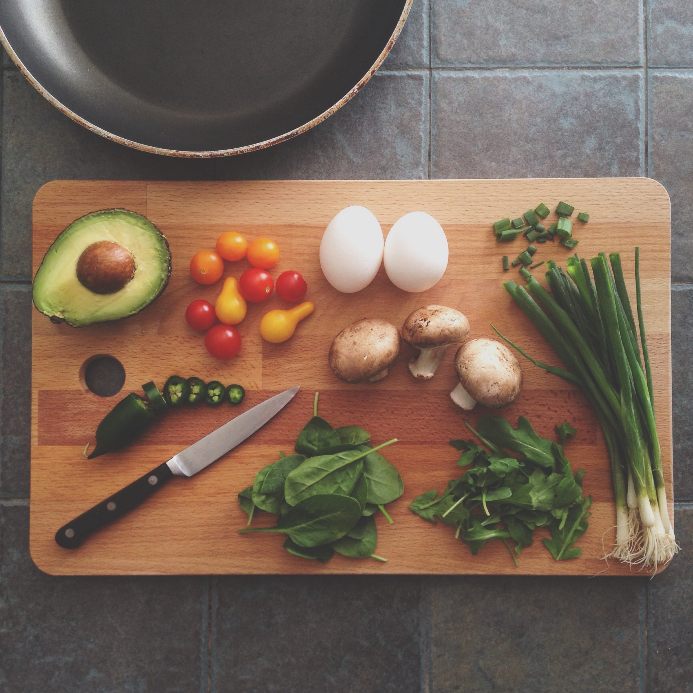 Various nutritious vegetables sit on a wood cutting board